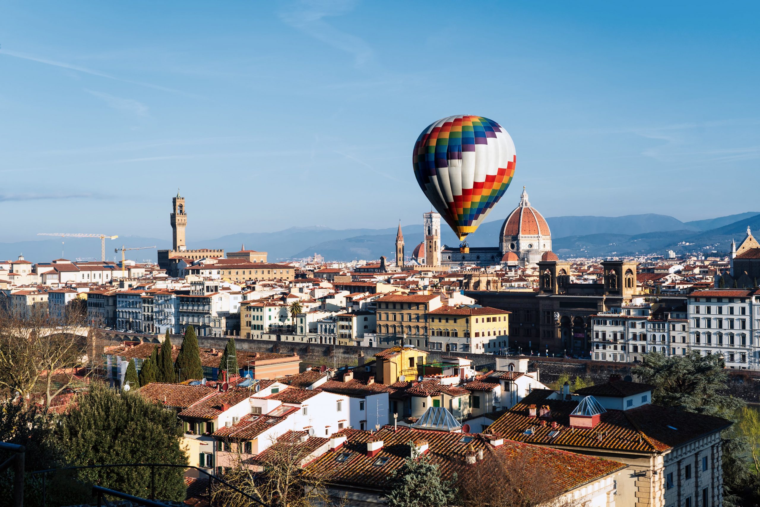 A large hot air balloon over the center of Florence.