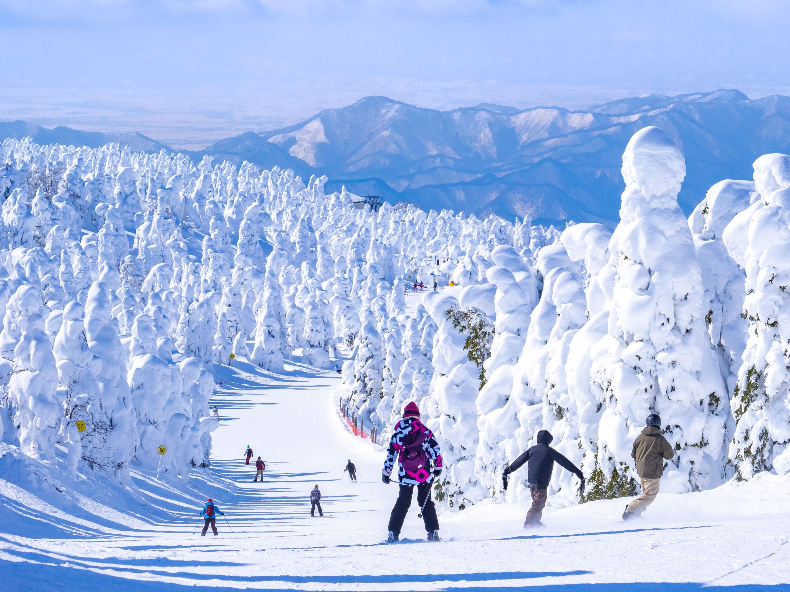 People racing down in a slope through the snow monsters.