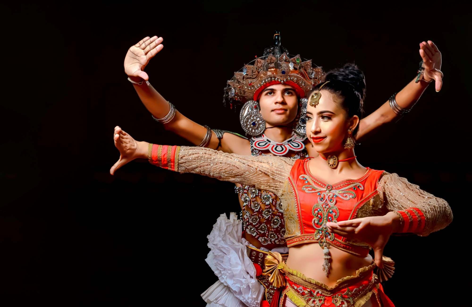 The dancers are performing with their arms outstretched in a stylized pose.