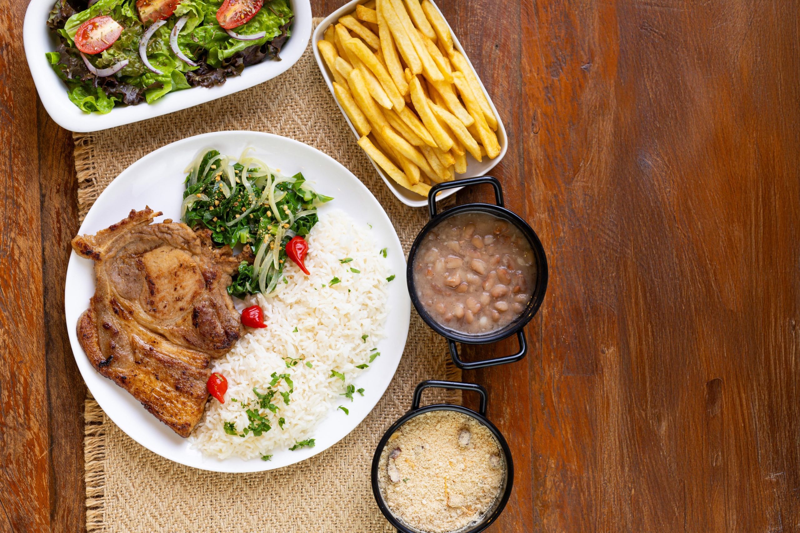 The steak is cooked on a grill (traditionally over hot embers or charcoal).