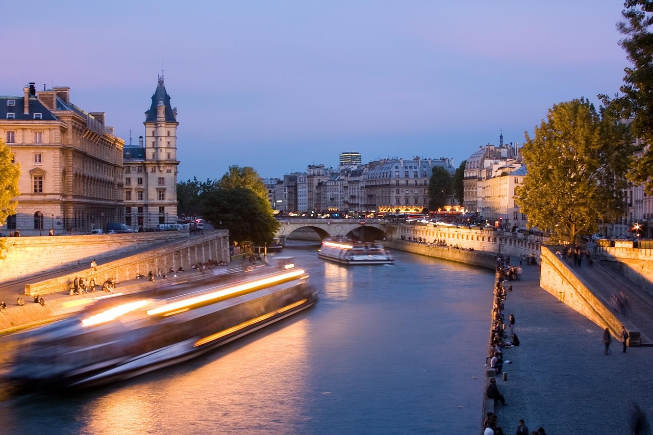 The Seine River sparkles at night, with glowing monuments reflected in its waters.