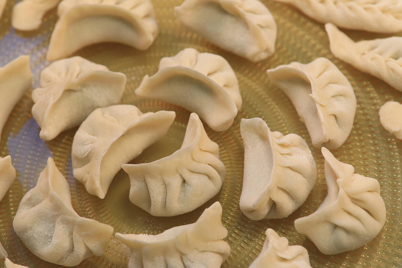 Northern China dumpling workshop with local families, hands shaping wrappers around fragrant fillings