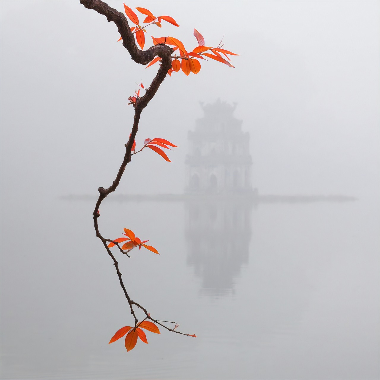 Hoan Kiem Lake at dawn in Hanoi Vietnam with sunrise Tai Chi and calm waters
